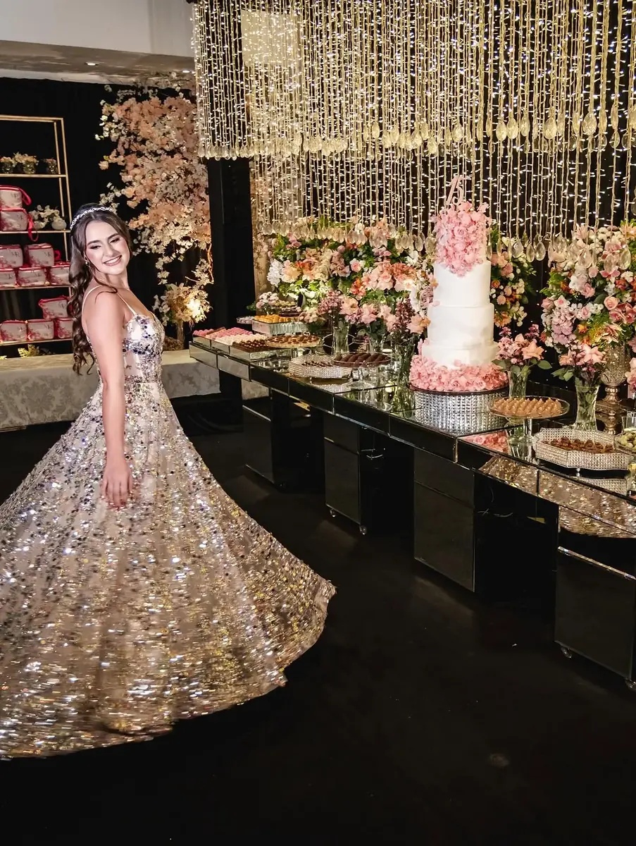 Debutante girando o vestido diante da mesa de doces